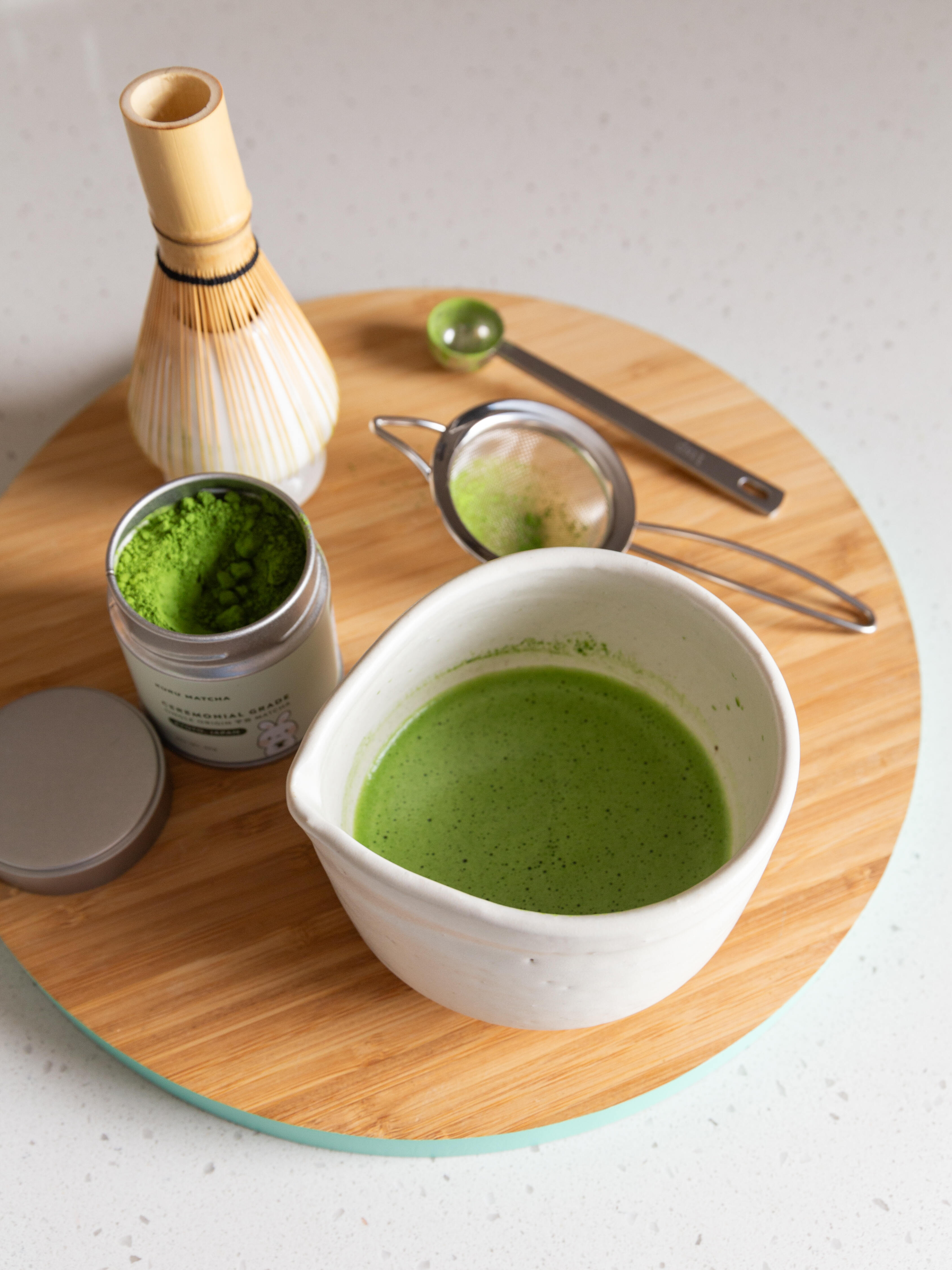 Overhead view of a matcha kit with whisk, bowl, and tools, designed for easy home preparation of matcha tea