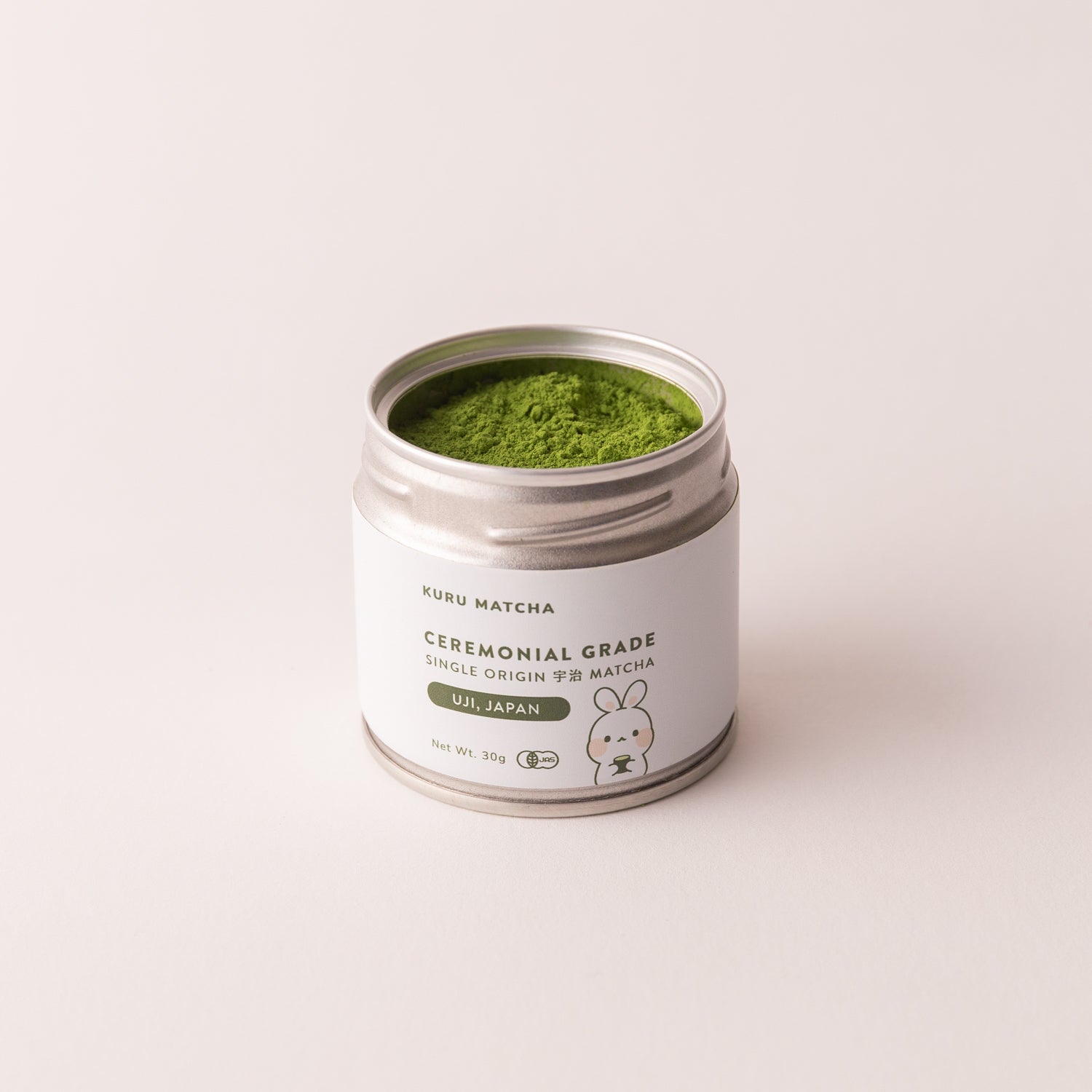 Organic matcha powder in tin with lid off, showcasing its fine texture and rich, natural colour